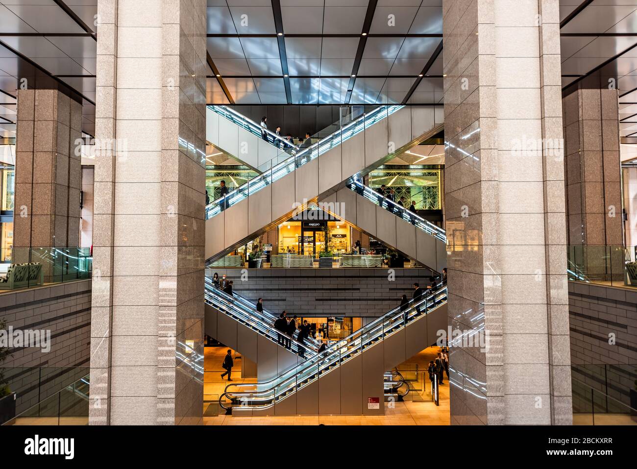 Tokyo, Giappone - 1 aprile 2019: Kyobashi Edopuland moderno centro affari edificio con architettura futuristica entrata di scale e scale mobili w Foto Stock