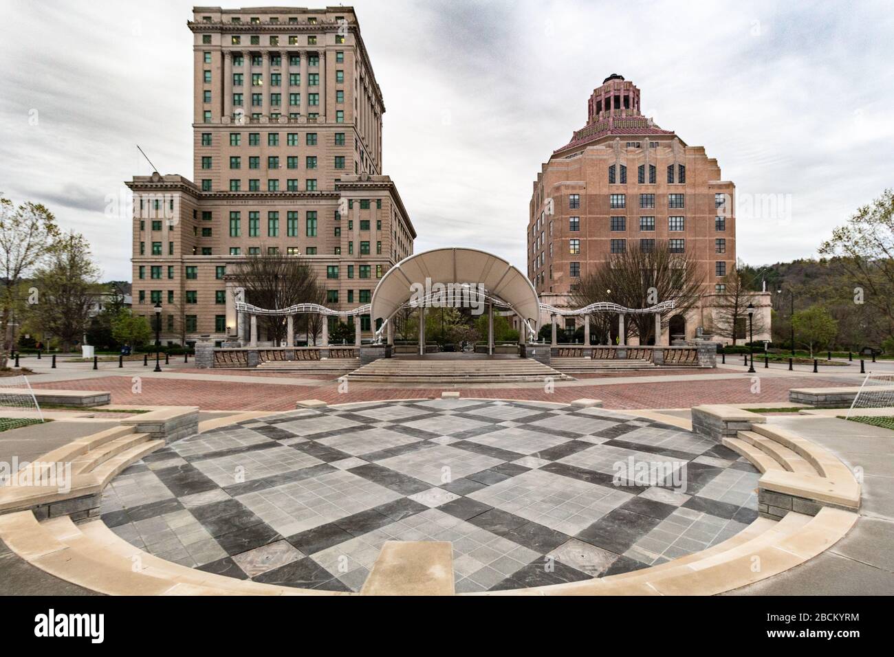 Il design geometrico audace della caratteristica di Splasheville Water (spento fino all'estate) bilancia contro gli edifici della città e della contea di Asheville, USA. Foto Stock