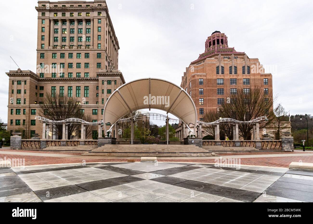 Il design geometrico audace della caratteristica di Splasheville Water (spento fino all'estate) bilancia contro gli edifici della città e della contea di Asheville, USA. Foto Stock