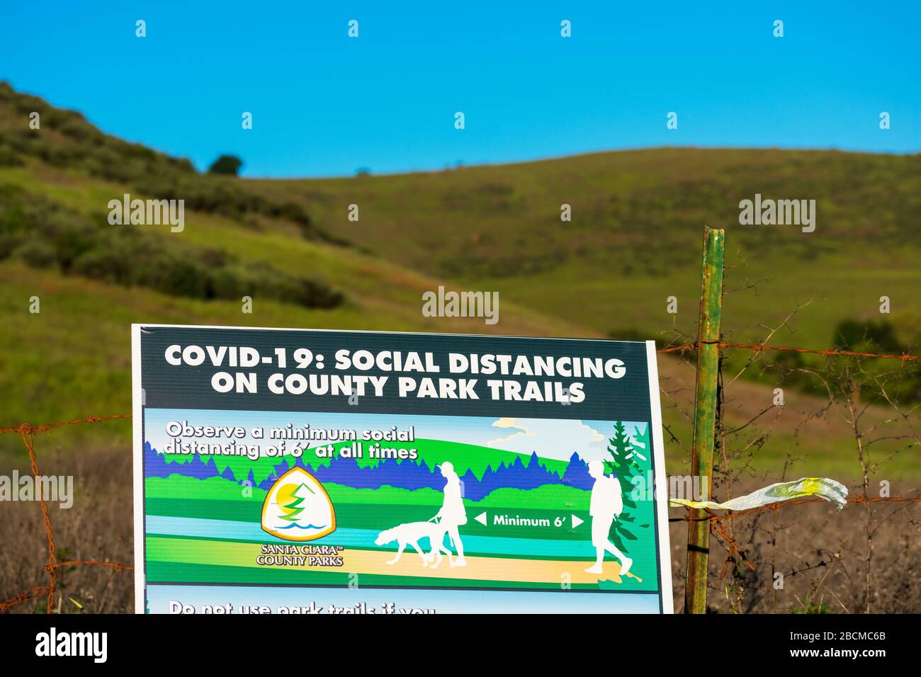 Segnale di distanza sociale sul sentiero escursionistico che richiede ai visitatori del parco della contea di praticare una distanza di sicurezza di almeno 6 piedi per prevenire la diffusione COVID-19 - Foto Stock