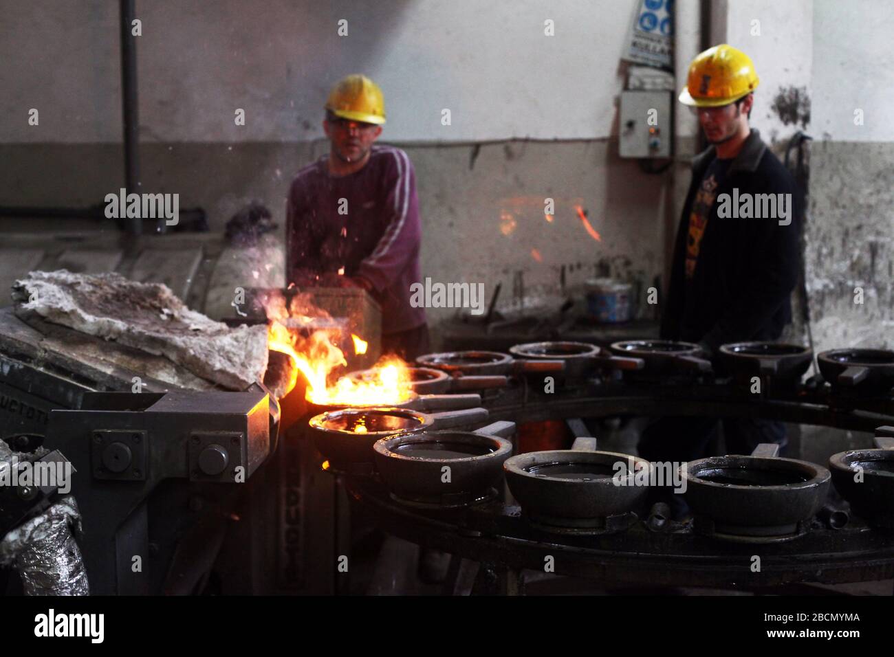 ISTANBUL, TURCHIA - 10 NOVEMBRE: I lavoratori turchi lavorano duramente in una fonderia il 10 novembre 2013 a Istanbul, Turchia. Metallo fuso versato dalla siviera. Foto Stock