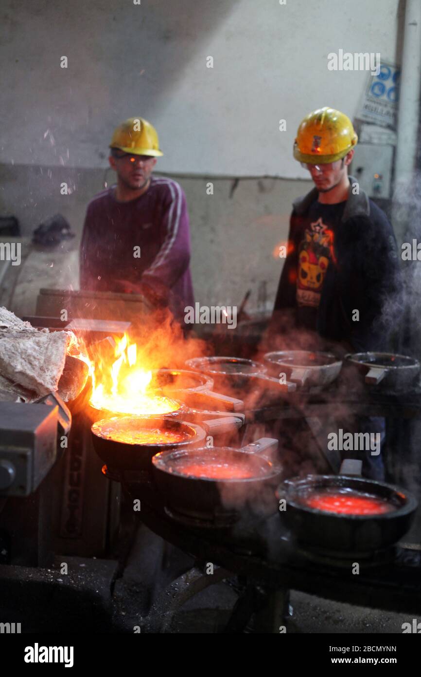 ISTANBUL, TURCHIA - 10 NOVEMBRE: I lavoratori turchi lavorano duramente in una fonderia il 10 novembre 2013 a Istanbul, Turchia. Metallo fuso versato dalla siviera. Foto Stock