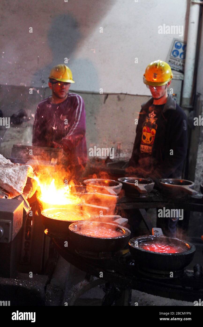 ISTANBUL, TURCHIA - 10 NOVEMBRE: I lavoratori turchi lavorano duramente in una fonderia il 10 novembre 2013 a Istanbul, Turchia. Metallo fuso versato dalla siviera. Foto Stock