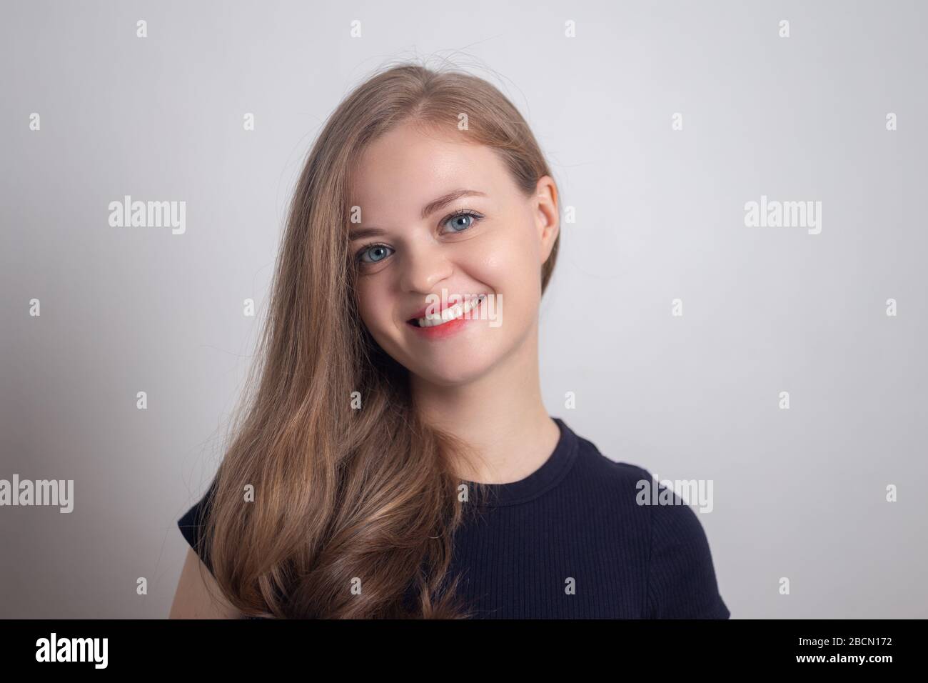 Sorridente giovane donna caucasica, guardando felice e positivo Foto Stock