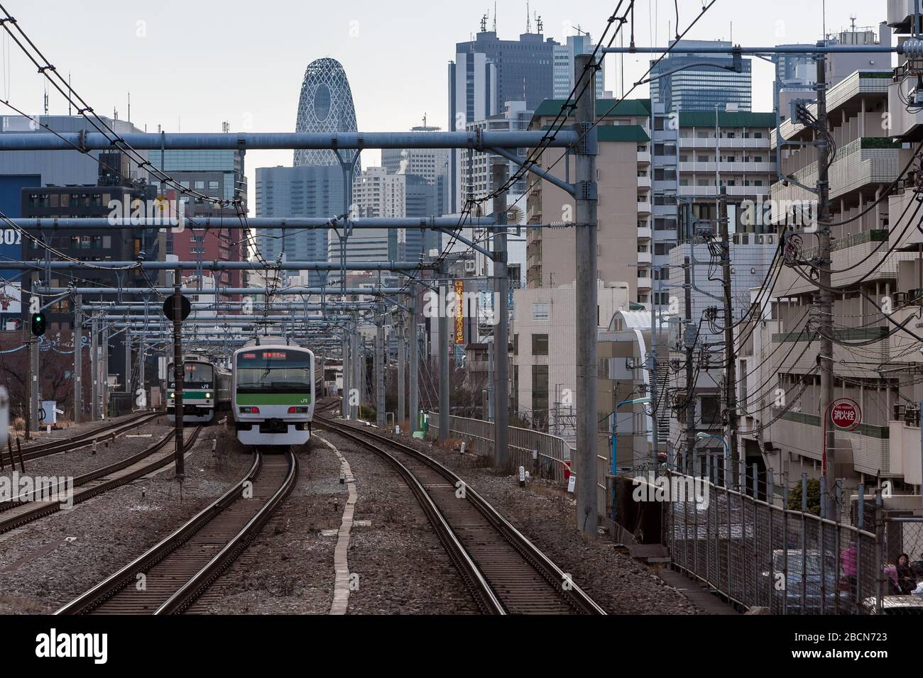 Un treno serie E231-500 sulla linea JR Yamanote di fronte allo skyline di Shinjuku con la Cocoon Tower nel centro, Tokyo, Giappone. Foto Stock