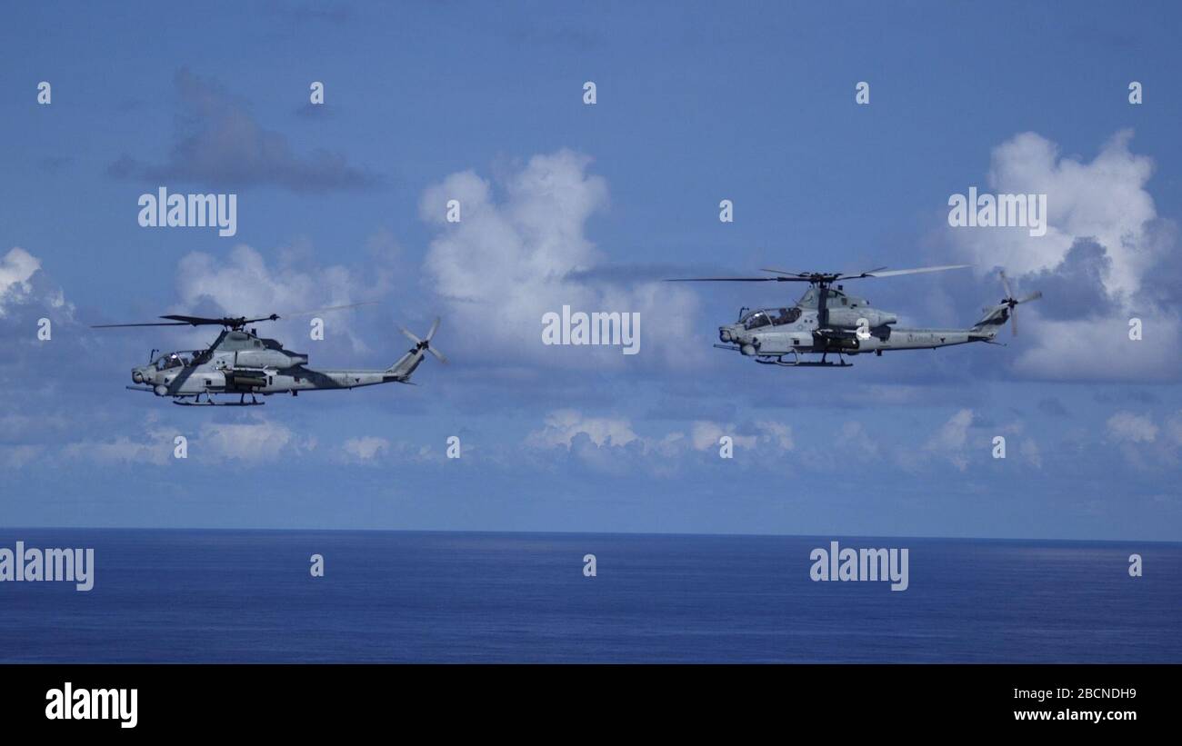PHILIPPINE SEA (23 marzo 2020) AH-1Z elicotteri da vipera con Marine Medium Tiltrotor Squadron (VMM) 265 (rinforzato), 31st Marine Expeditionary Unit (MEU), volare in formazione durante un lancio DI FUOCO marittimo a fuoco diretto con missile da sidewinder AIM-9M. Durante l'esercizio, gli elicotteri di attacco sono decollati dalla nave di atterraggio della classe San Antonio USS Green Bay (LPD 20) per proteggere la task force anfibia da una minaccia marittima simulata. L'America Expeditionary Strike Group, team 31st MEU, opera nell'area operativa della 7th Fleet degli Stati Uniti per migliorare l'interoperabilità con alleati e parti Foto Stock