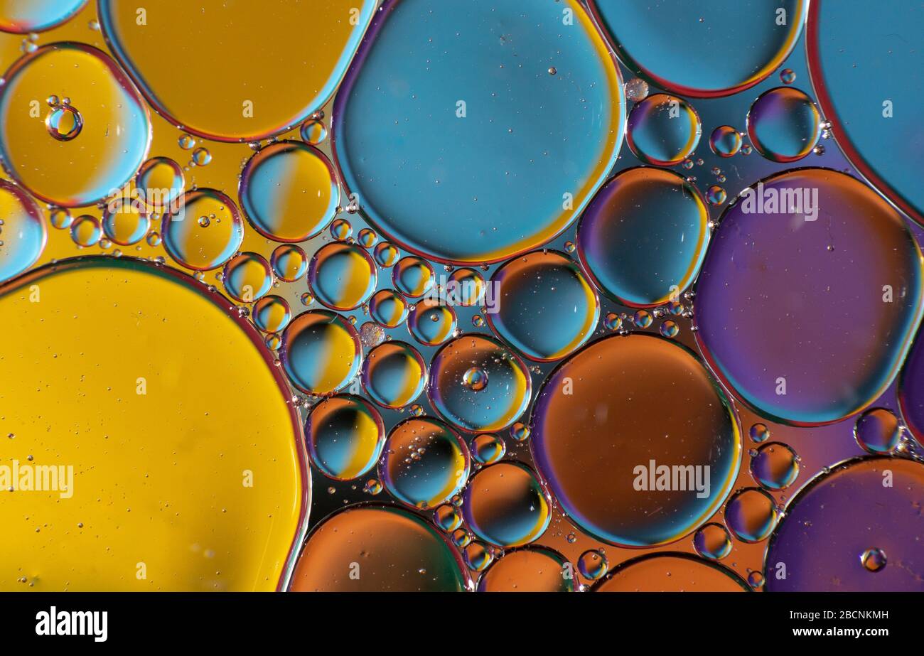 Gocce d'olio su una superficie d'acqua con colori brillanti (immagine di sfondo astratta) Foto Stock