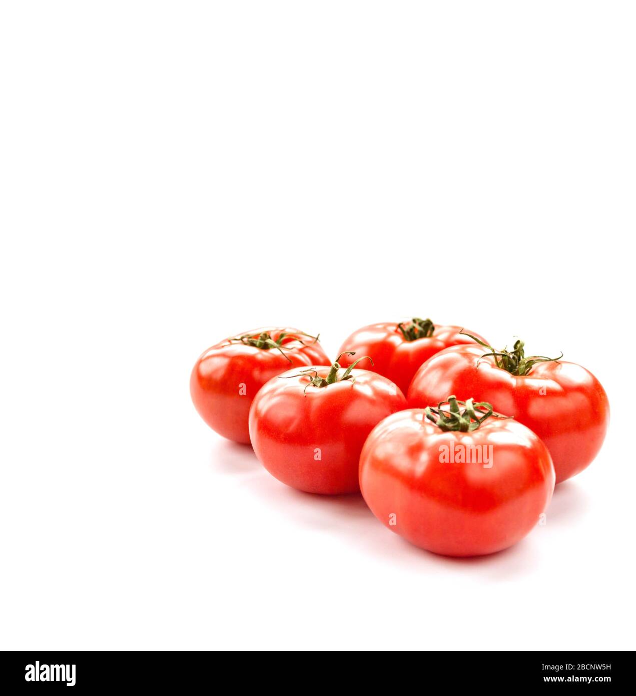 Pomodoro poche verdure isolate su sfondo bianco ritagliato in primo piano verticale. Messa a fuoco selettiva. Foto Stock