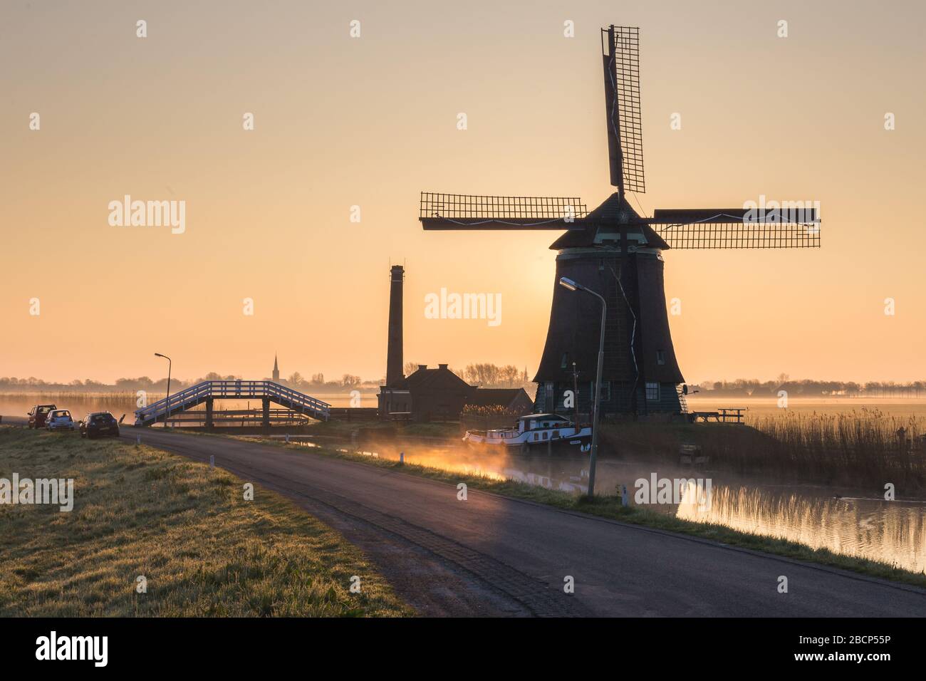 Il mulino a vento De Kaagmolen di fronte a un canale e barca, Olanda del Nord, Paesi Bassi Foto Stock
