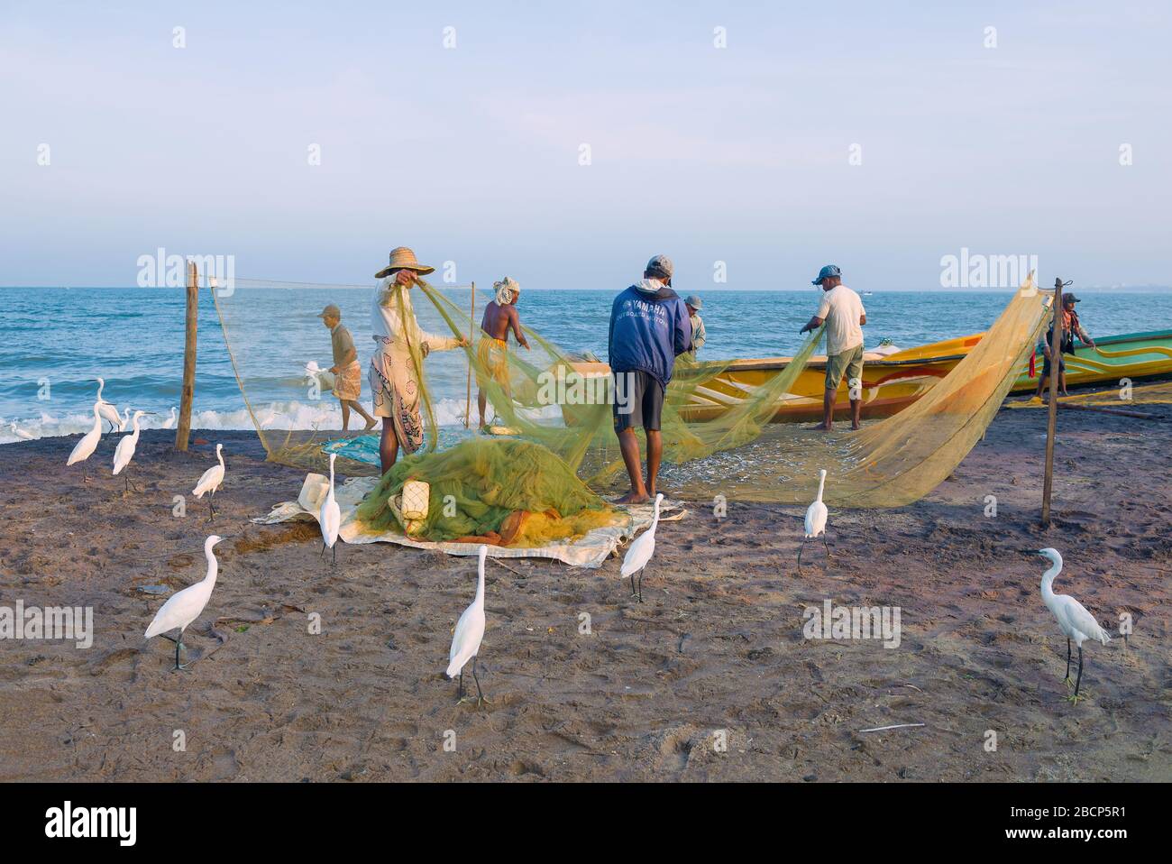 NEGOMBO, SRI LANKA - 03 FEBBRAIO 2020: I pescatori disassemblano la rete dopo la pesca sulla riva dell'Oceano Indiano Foto Stock