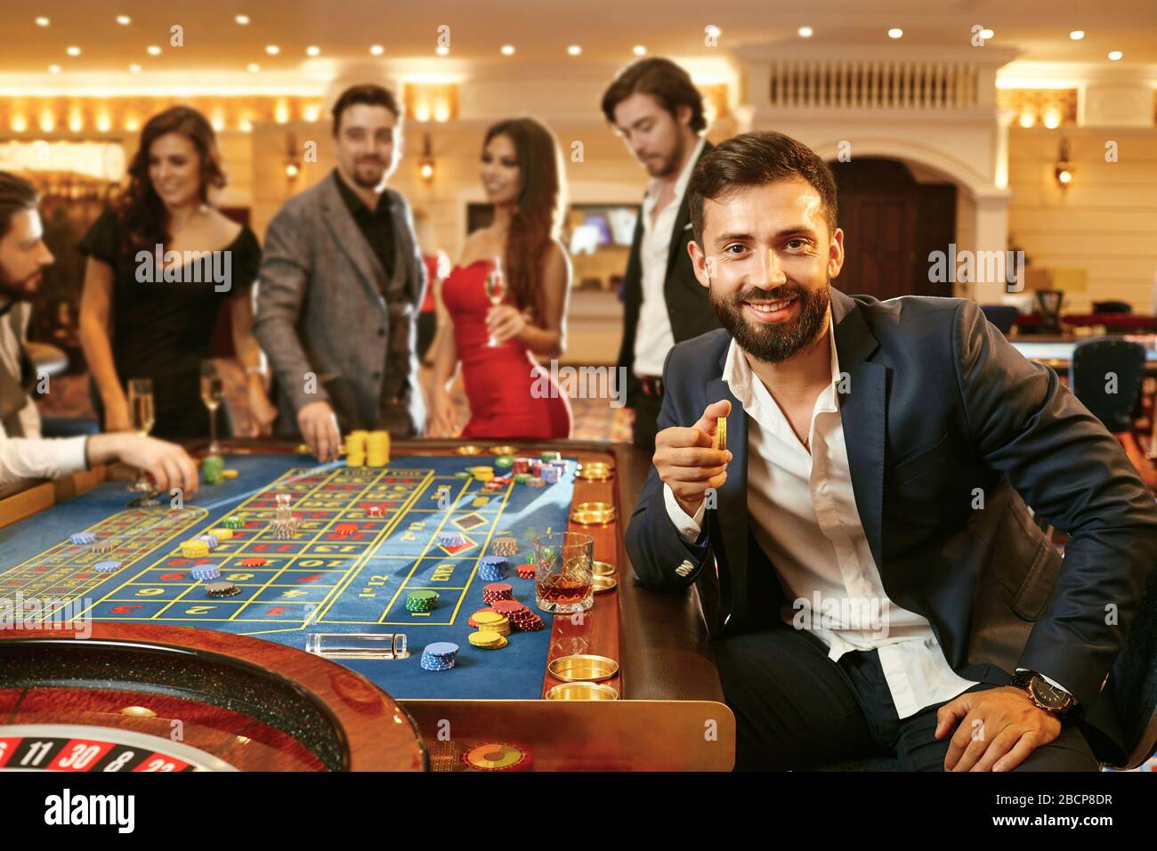 Un uomo con le fiches nella sua mano che gioca a poker ad una roulette di poker del casinò. Foto Stock