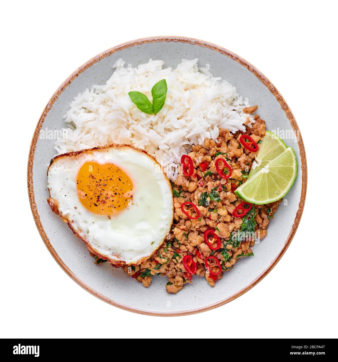 Pad Krapow Gai - pollo al basilico tailandese con riso e uova fritte isolato su sfondo bianco. Pad Krapow è un piatto di cucina tailandese con pollo tritato o maiale Foto Stock