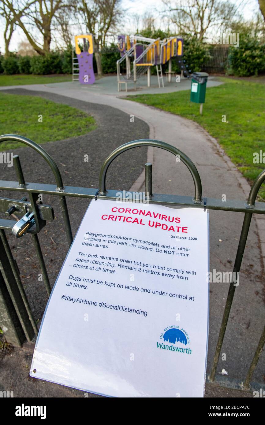 Un cartello su Wandsworth Common avverte dell'importanza di non entrare in strutture chiuse durante la pandemia di coronavirus Foto Stock