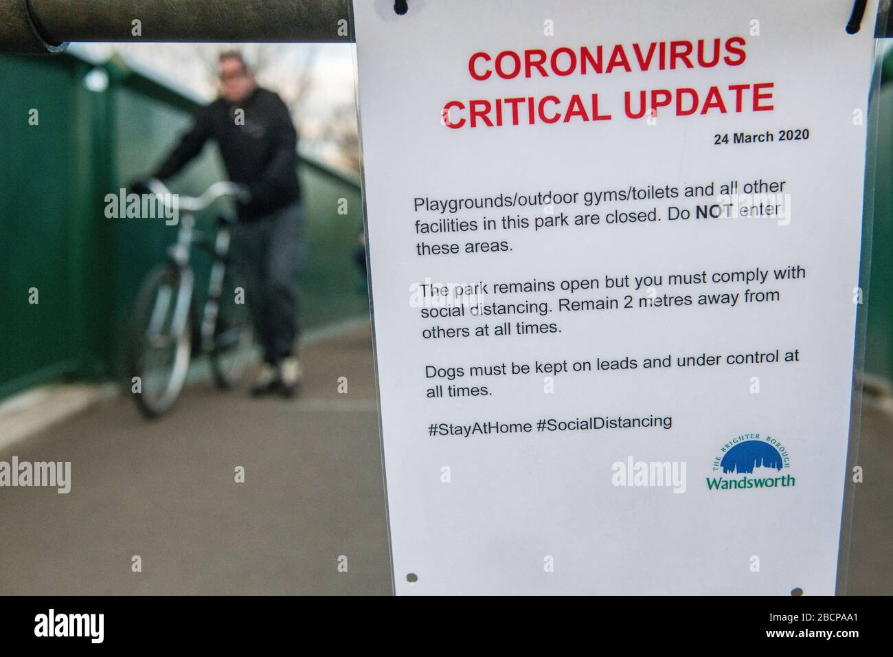 Un cartello su Wandsworth Common avverte dell'importanza di non entrare in strutture chiuse durante la pandemia di coronavirus Foto Stock