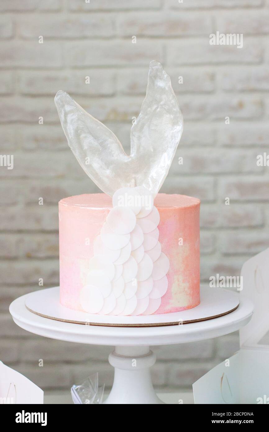 Caramelle a tema Mermaid con torta, cupcake, macaroon e biscotti. Macaroni a forma di conchiglia di mare con perle. Torta rosa con coda di mermaid al caramello. Foto Stock