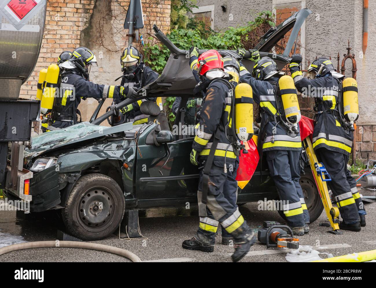 I pompieri salvano il pilota intrappolato durante una simulazione di incidenti stradali con auto, treno e camion. Pompieri con respiratori e Hyd Foto Stock