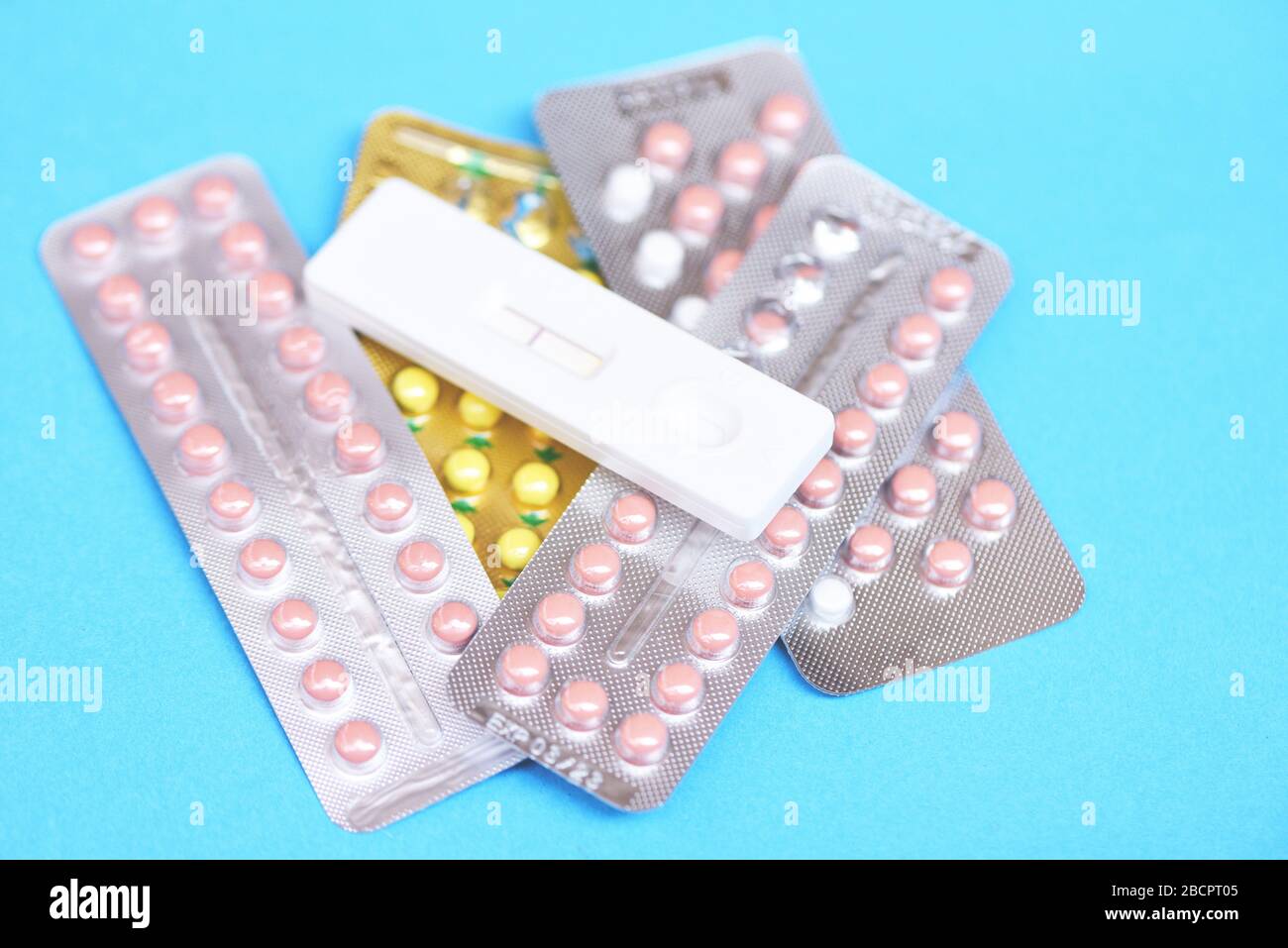 Pillole contraccettive e test di gravidanza su sfondo blu / contraccettivi controllo delle nascite significa prevenire la gravidanza Foto Stock
