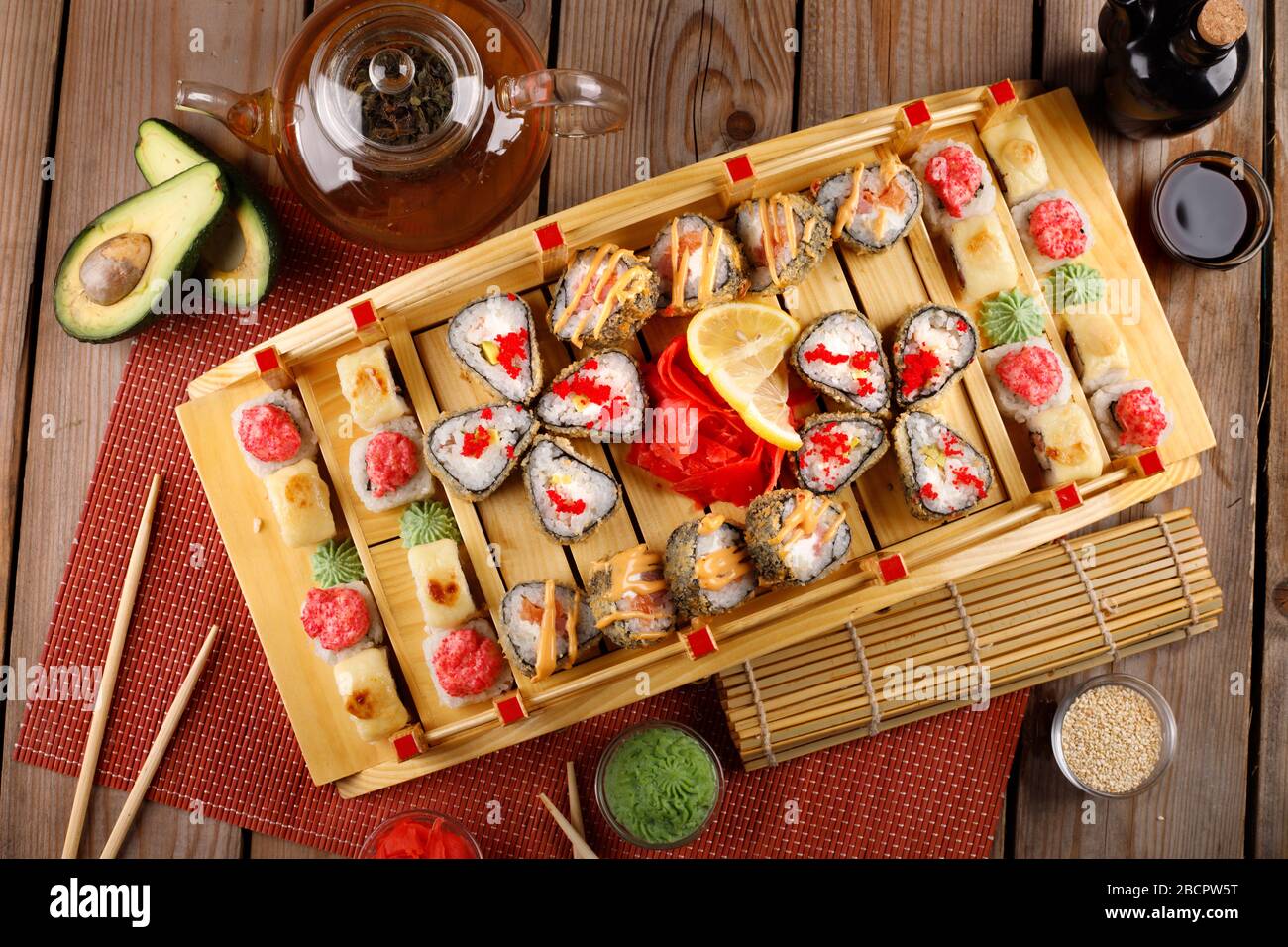 grande set di sushi colorato in un piatto quadrato. su uno sfondo di legno Foto Stock