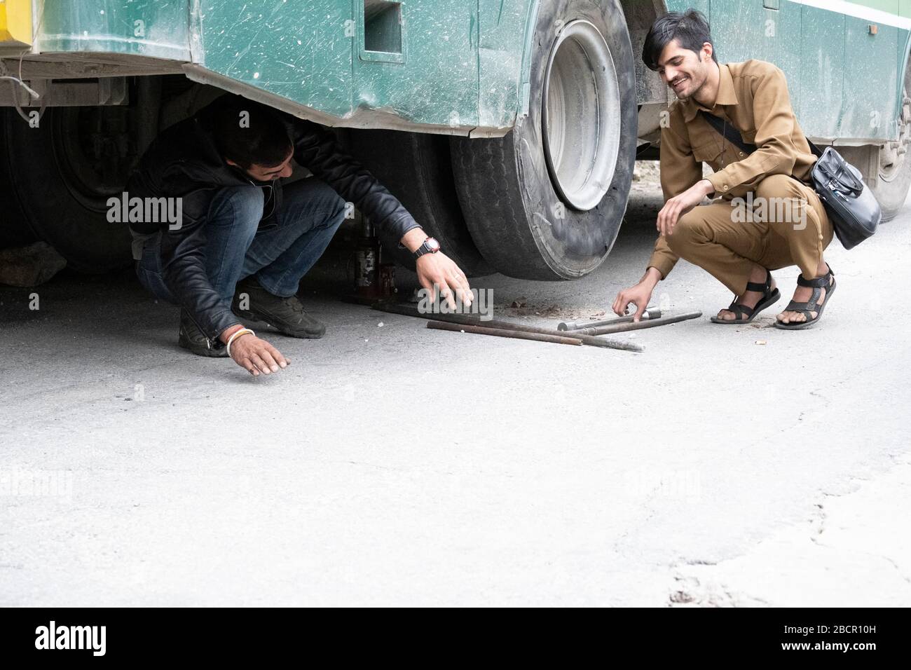 Il pilota e direttore di una strada Himachal si preparano a cambiare un pneumatico sulla strada Sangla Rakchham. Foto Stock