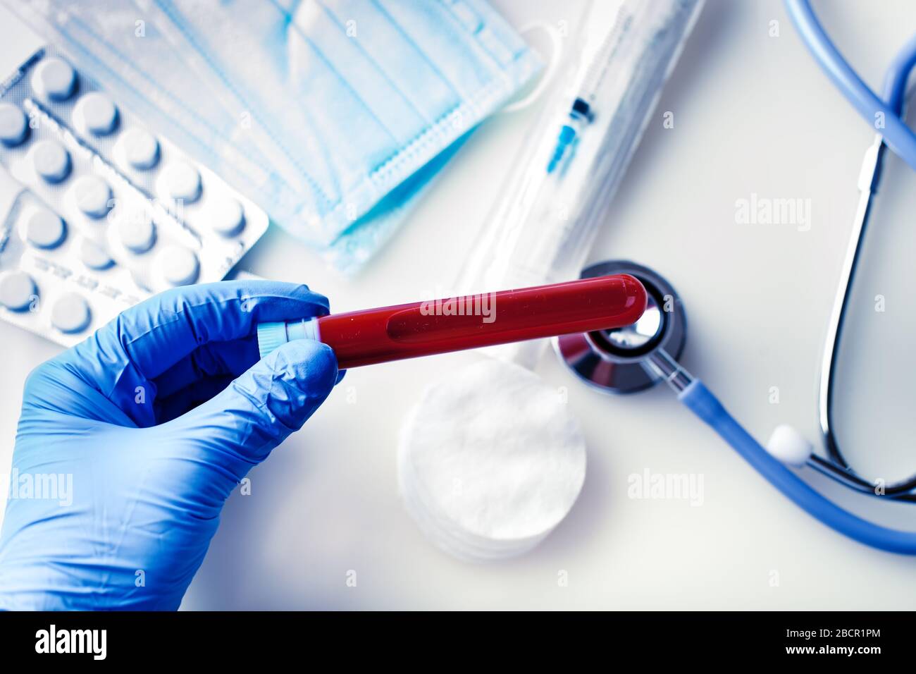L'epidemia di coronavirus. Mano di un medico contenente un flacone di campione di sangue. Foto Stock