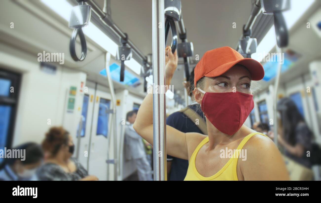 Donna viaggio caucasico giro a terra treno airtrain con indossare maschera medica protettiva. Ragazza turistica all'airtrain con respiratore. Maschera persone. Foto Stock