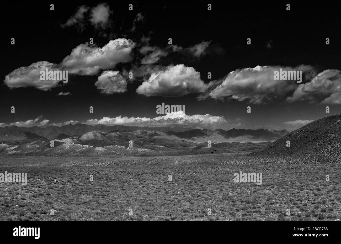 Natura del Kirghizistan. La gamma Trans-Alay. Pamir Mountain System. Giorno nuvoloso. Terreno collinare. Bianco e nero. Foto Stock