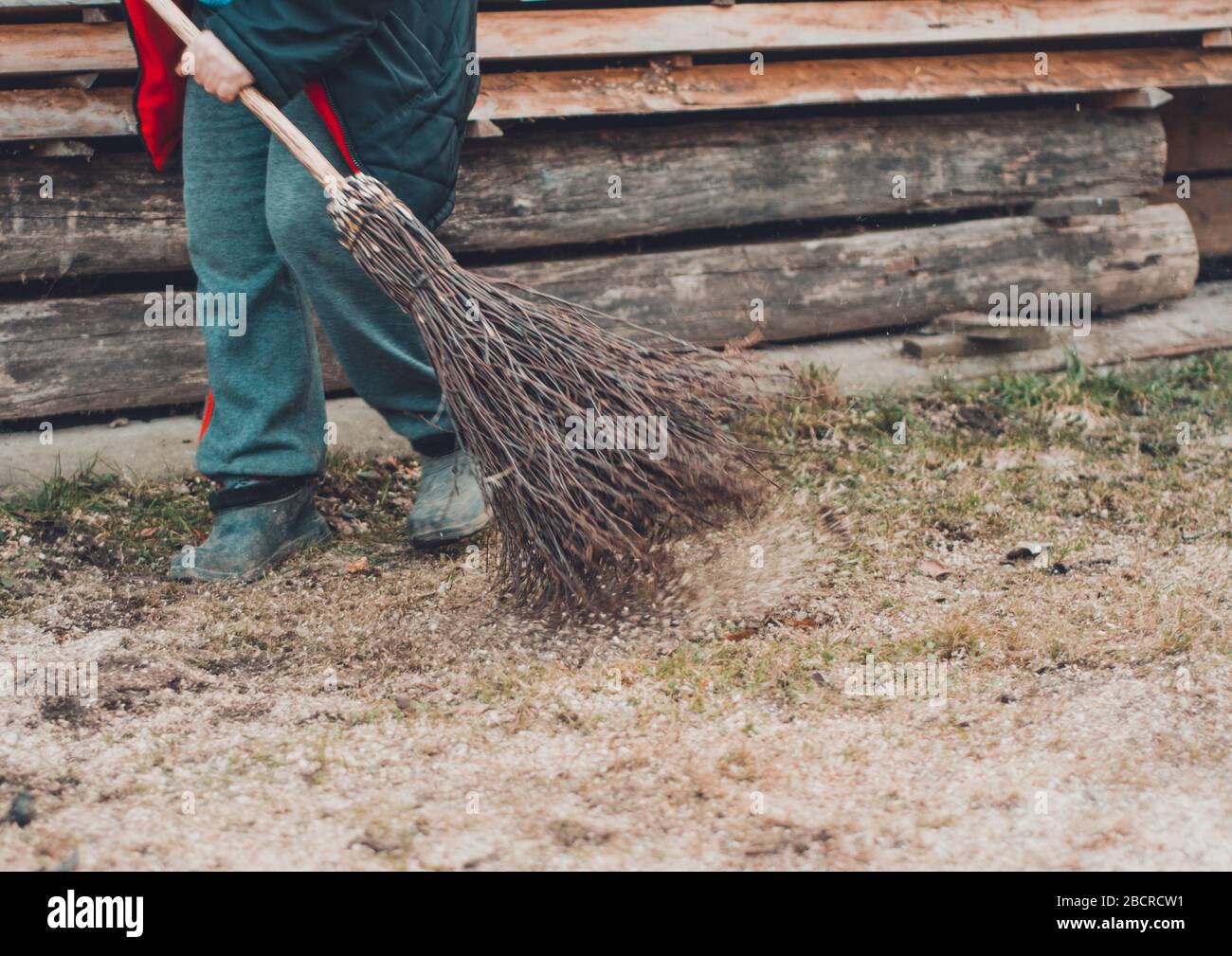 Una donna in un villaggio pulisce un cortile vicino alla sua casa con una scopa  di betulla. 2019 Foto stock - Alamy