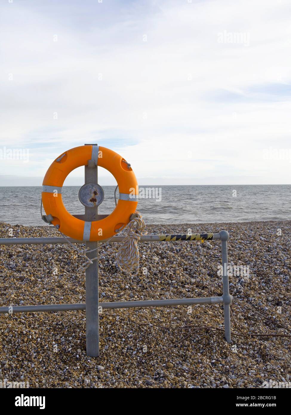 Lifebuoy su ghiaia, spiaggia di ghiaia. Precauzioni per l'anello di sicurezza. Foto Stock