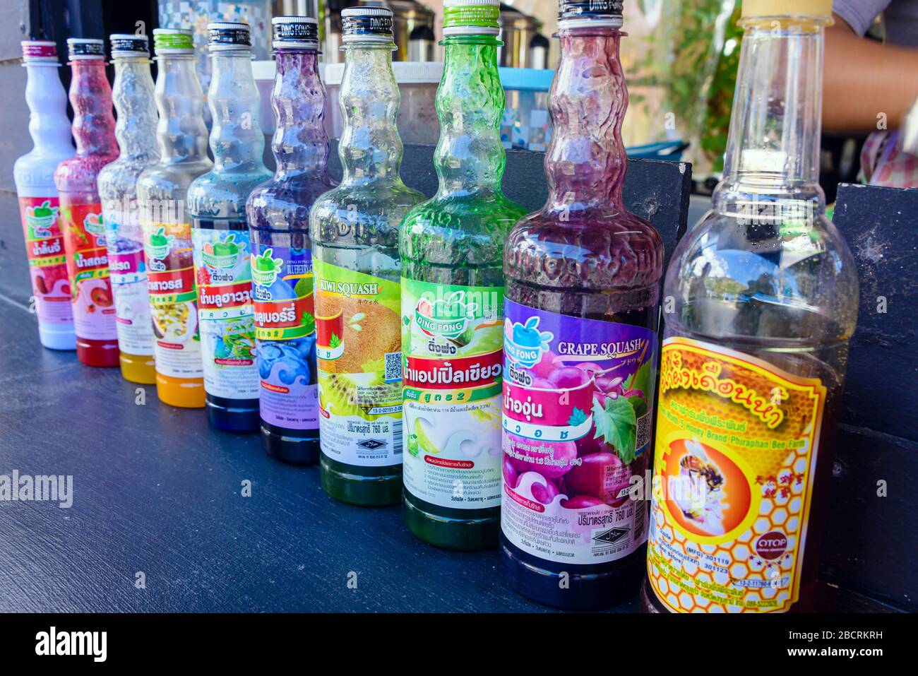 Bottiglie di sciroppi aromatizzati presso un bar sulla strada per preparare frullati e bevande ghiacciate, Kata Beach, Phuket, Thailandia Foto Stock