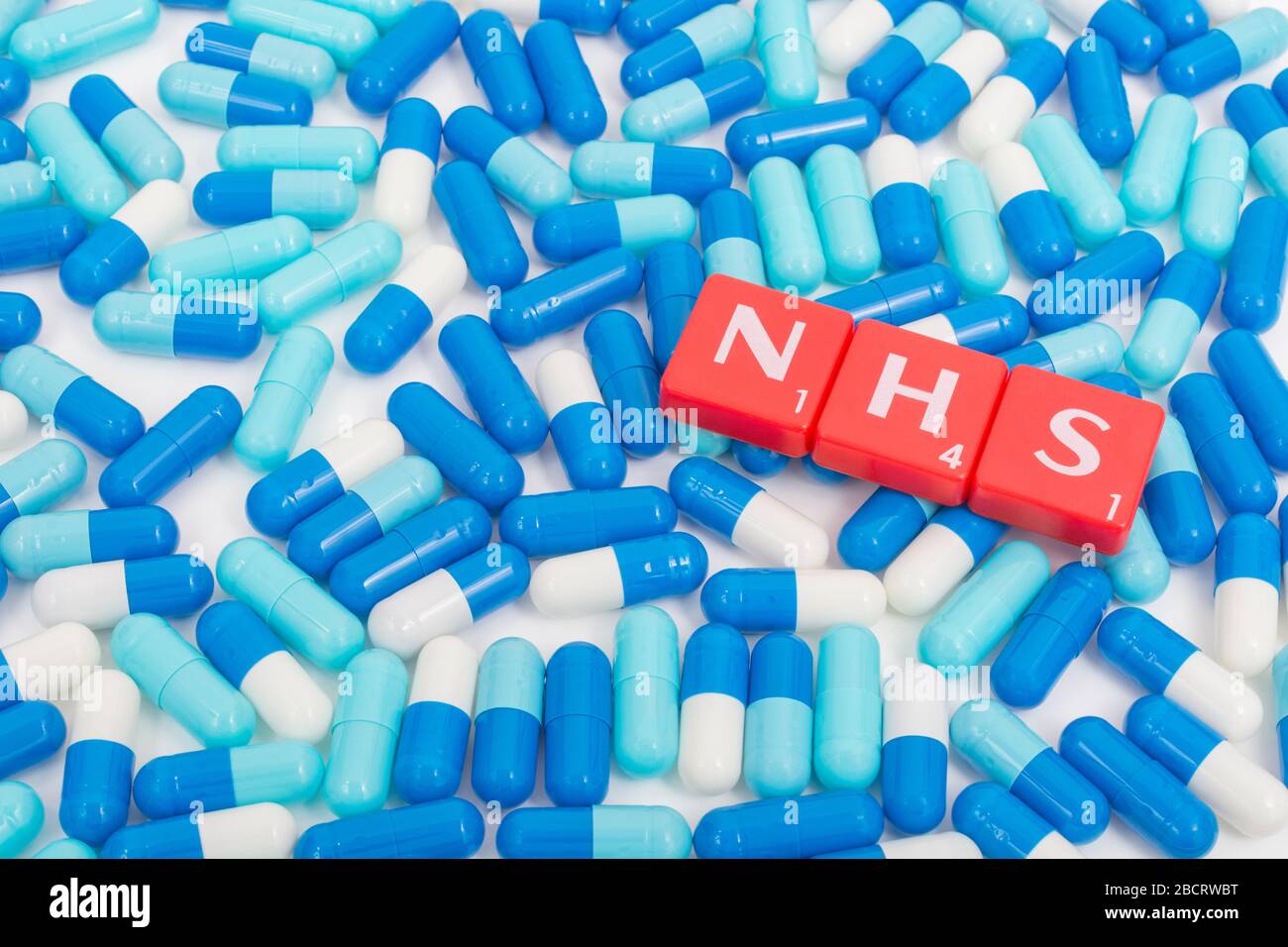 Piastrelle per lettere NHS e pillole blu assortite. Per il 75 ° compleanno NHS, eroi NHS, prescrizioni NHS, UK National Health Service, medicina nel Regno Unito Foto Stock