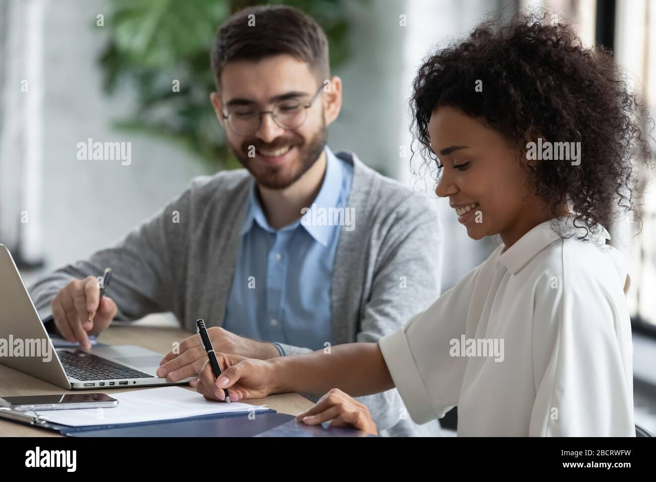 Primo piano african american businesswoman firmando accordo di partenariato concetto. Foto Stock