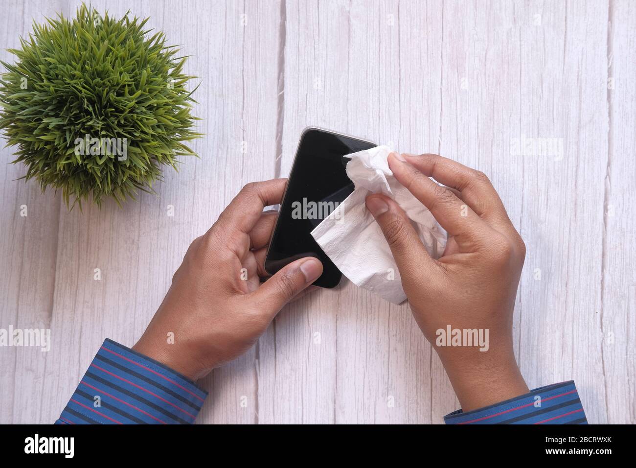 Primo piano di uomo che pulisce smartphone o prevenzione delle malattie. Foto Stock