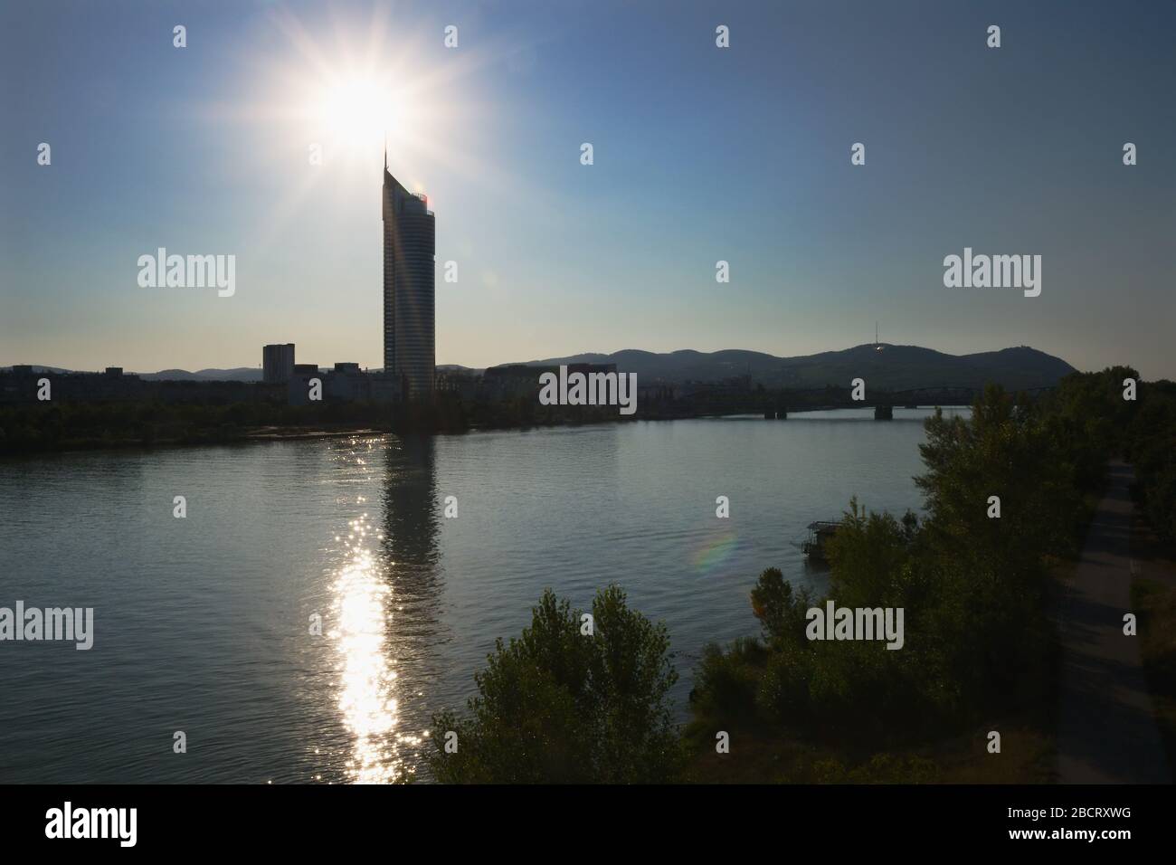 Blick von der Brigittenauer Brücke Richtung Millennium Tower a Wien Brigittenau mit der Sonne an der Spitze des Turms Foto Stock