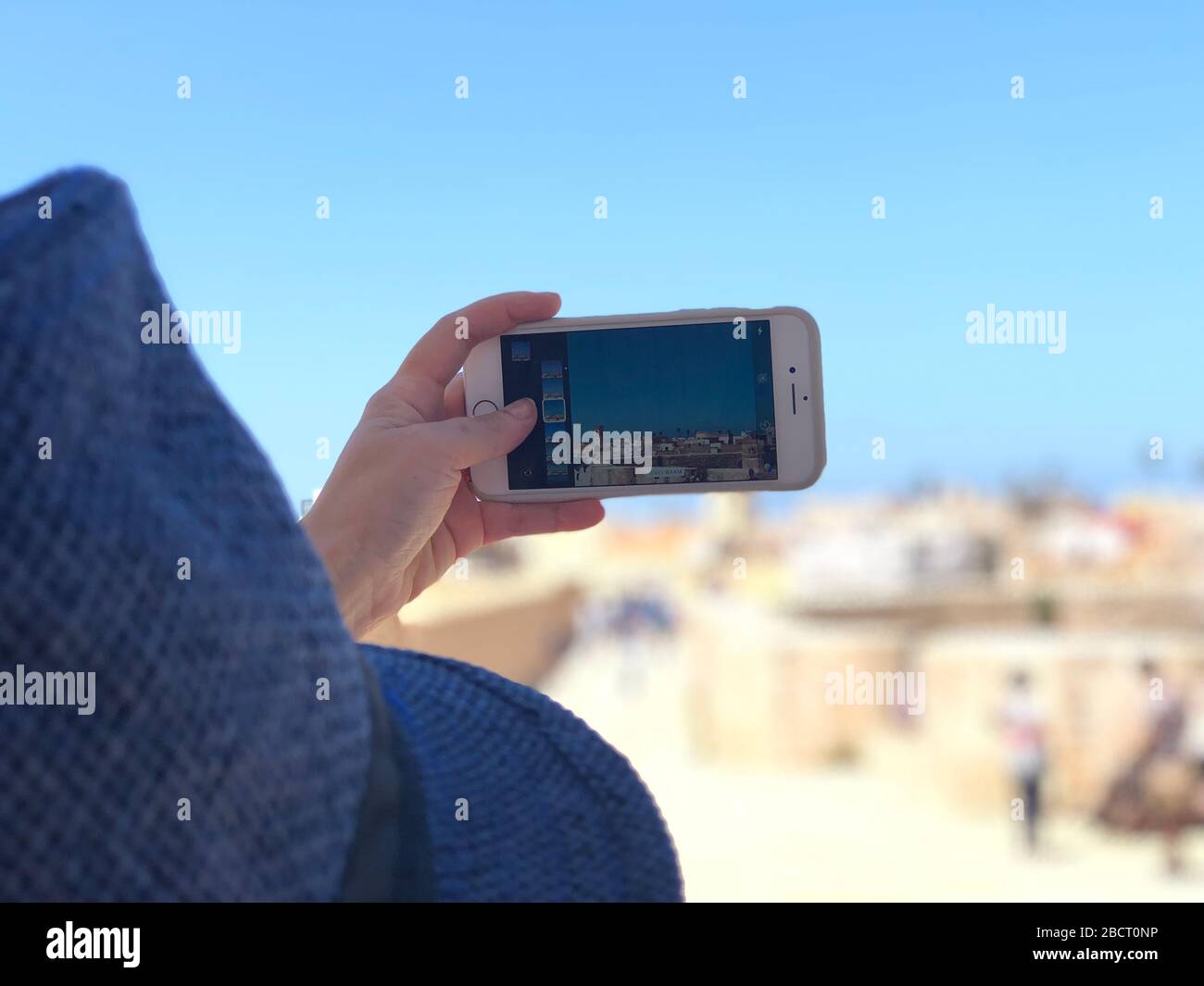 Telefono cellulare con mano femminile con immagine di El Jadida, Marocco Foto Stock
