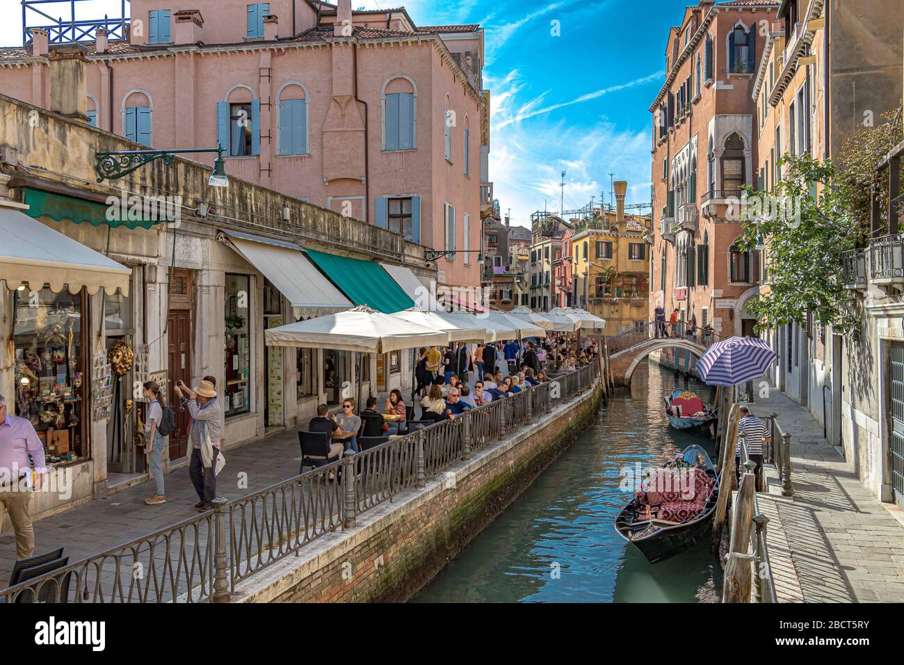 Persone che hanno bevande fuori da un ristorante sul canale sulla Fondamentina de l'Osmarin nel quartiere San Marco di Venezia Foto Stock