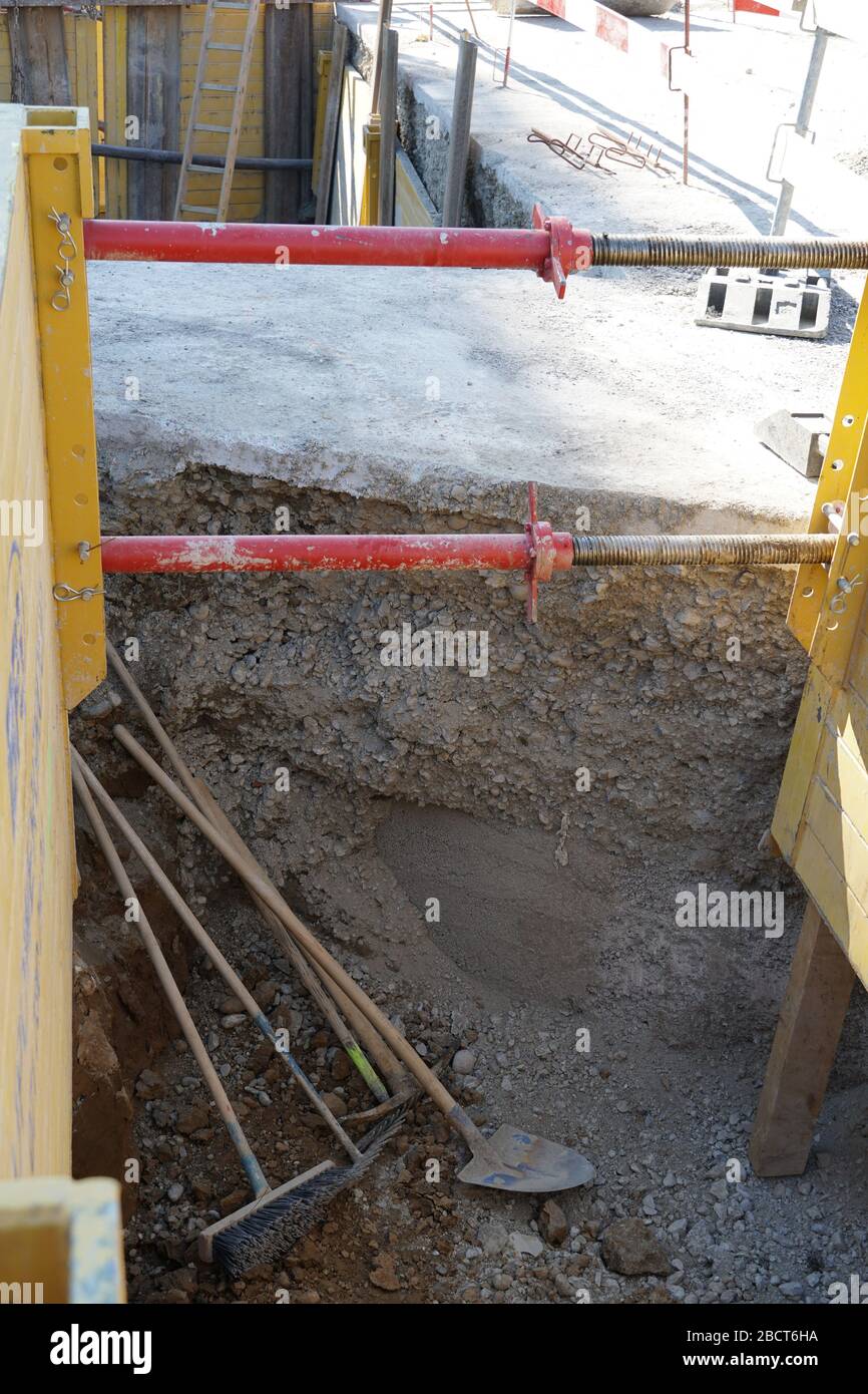 Attrezzatura accessoria lasciata in costruzione o buca di costruzione, una scopa una pala ed un mattone o un pickaxe. Questi strumenti non sono utilizzati solo in costrutto Foto Stock