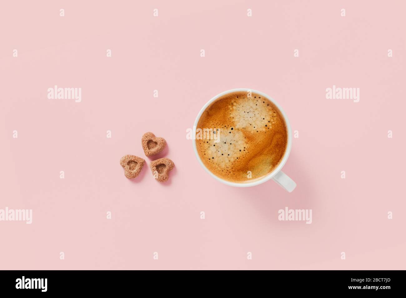 Tazza del mattino di caffè forte con tre pezzi di zucchero a forma di cuore. Foto Stock