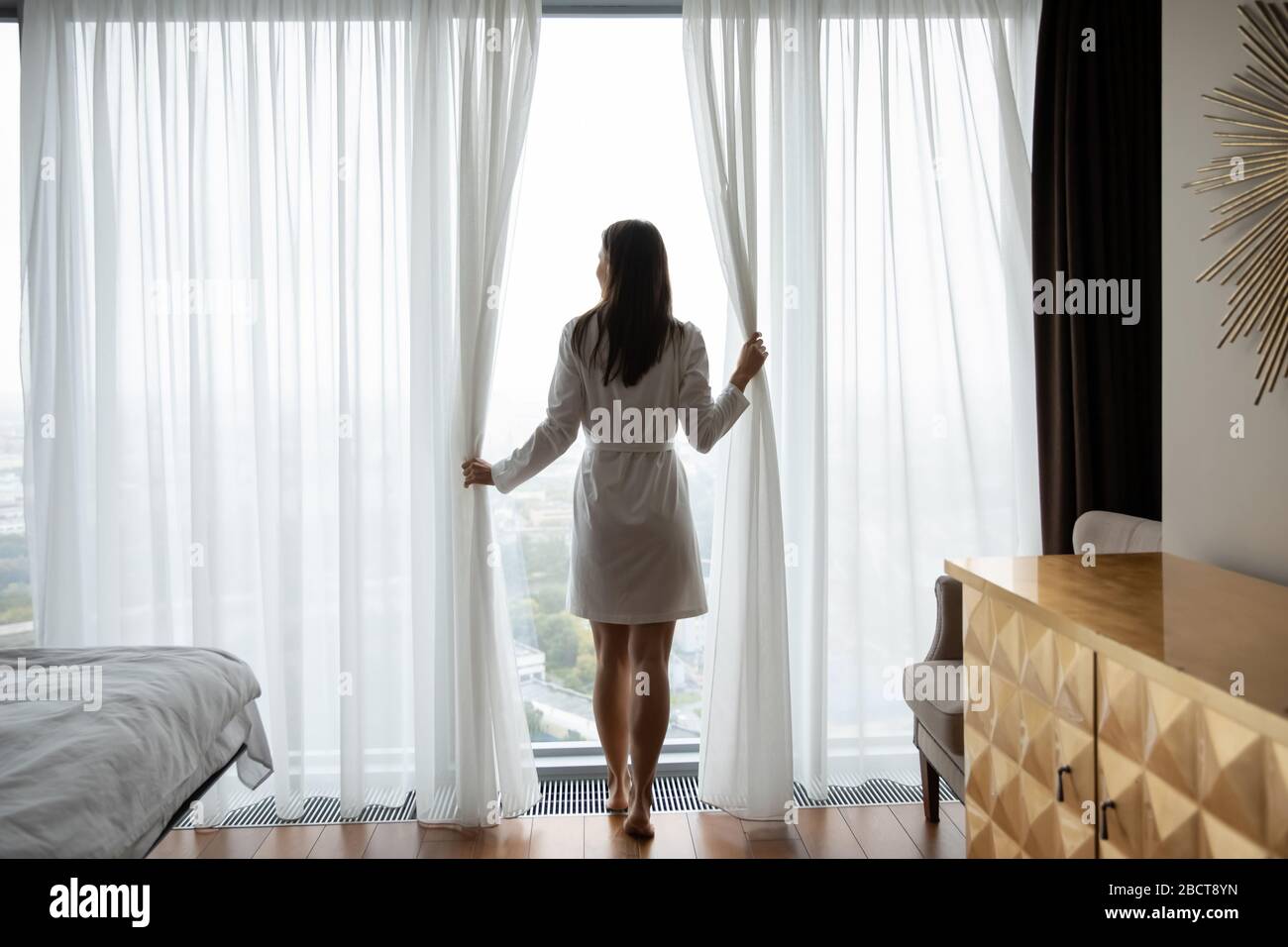 Giovane donna in accappatoio svegliarsi accogliente nuovo giorno Foto Stock