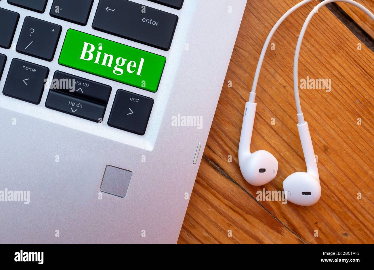 Laptop con cuffia e parola Bingel sulla tastiera. Bingel è una piattaforma belga per la scuola domestica. Foto Stock