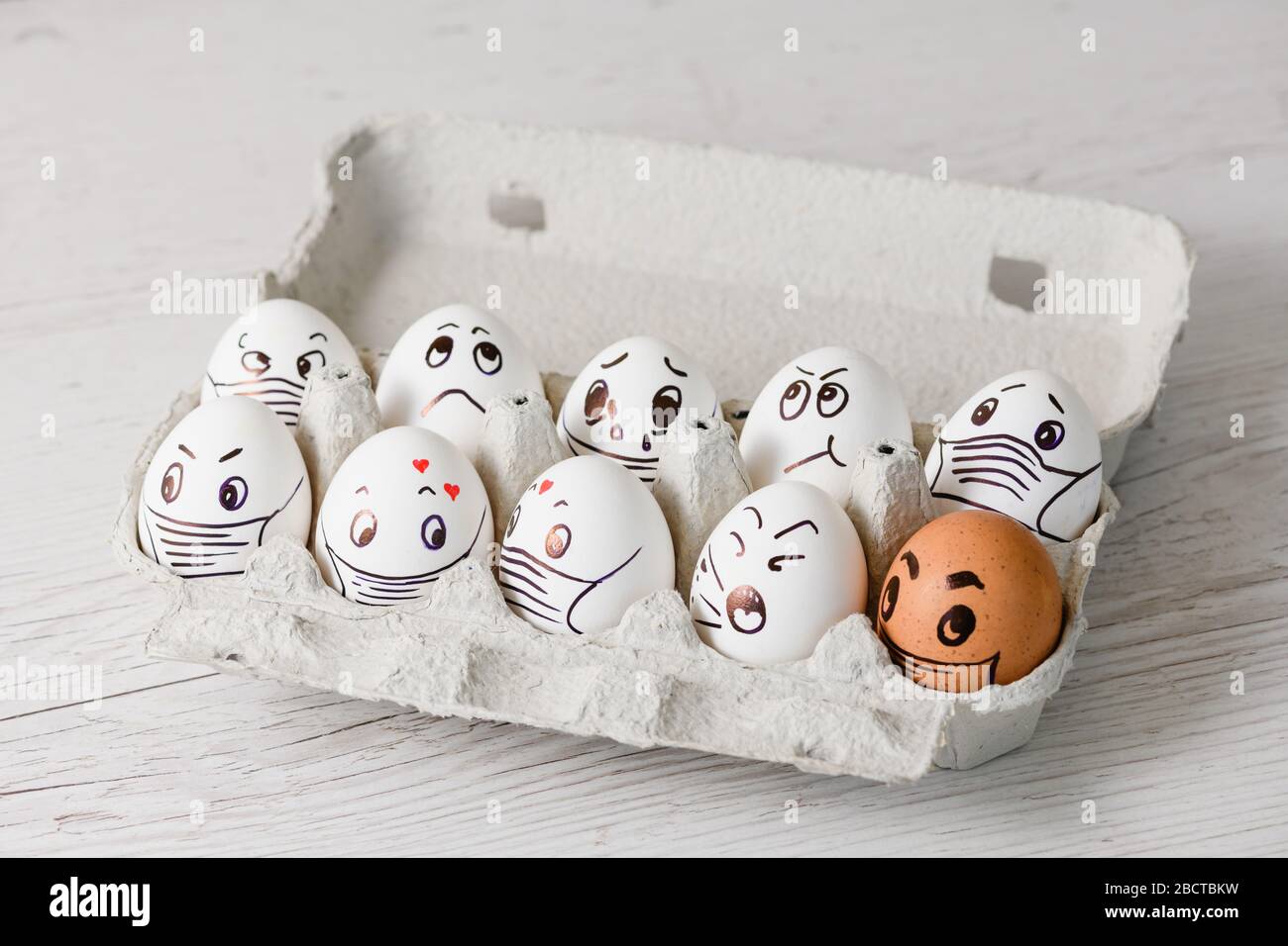 Volti divertenti disegnati sulle uova di Pasqua con diverse emozioni - dolore, felicità, sorpresa, scoppio, pianto a vassoio di carta in maschera per il quarant coronavirus Foto Stock
