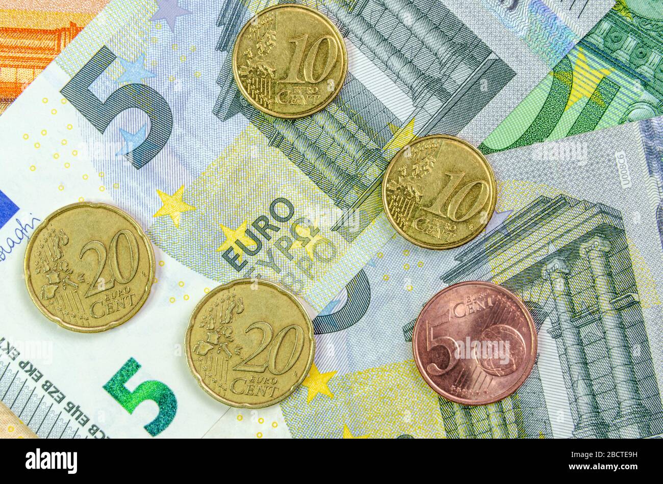 5, 10 e 20 centesimi di euro si trovano sullo sfondo delle banconote in euro. concetto di cambiamento e inflazione Foto Stock