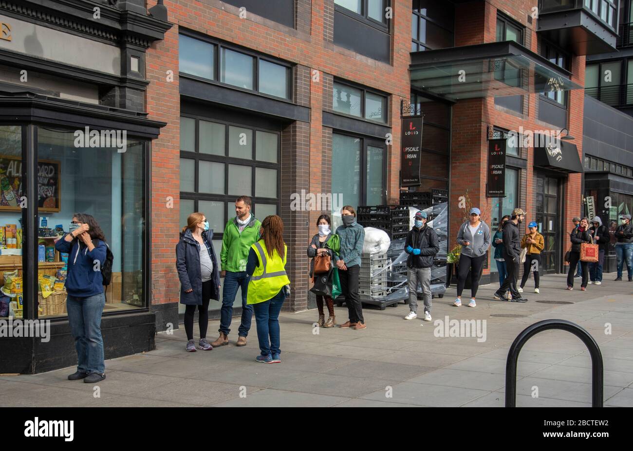 Washington, DC, 04 04 2020. Gli acquirenti mantengono la distanza sociale in attesa di entrare in una storia locale di alimentari, 4 aprile 2020. Foto Stock
