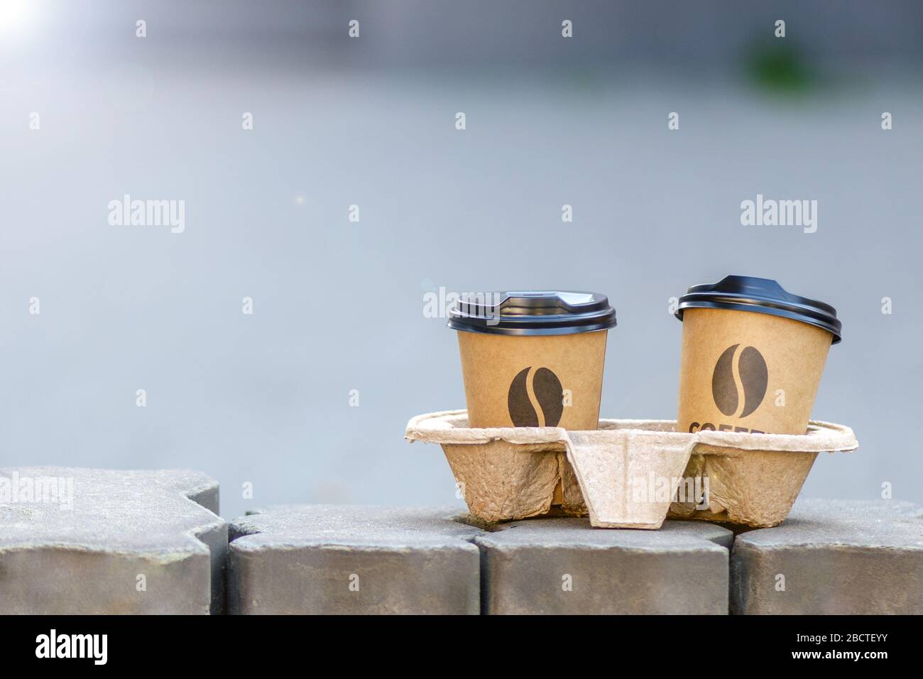 caffè di strada. 2 tazze di caffè nel supporto. Il caffè da asporto è in piedi per strada. Concetto di comunicazione con gli amici Foto Stock