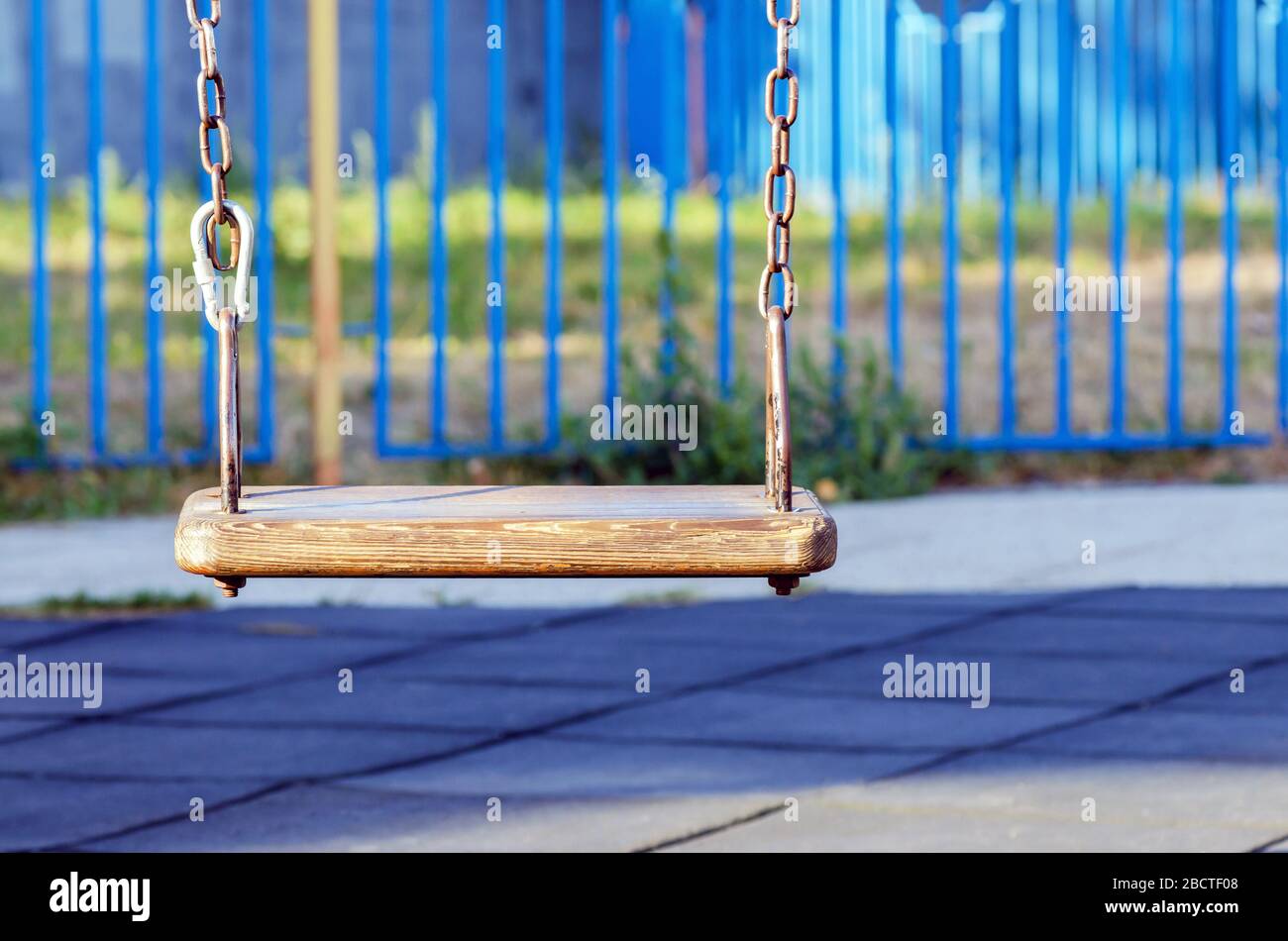 swing vuoto al parco giochi. Il concetto di infanzia e divertimento. Asse e catena vecchio e graffiato Foto Stock