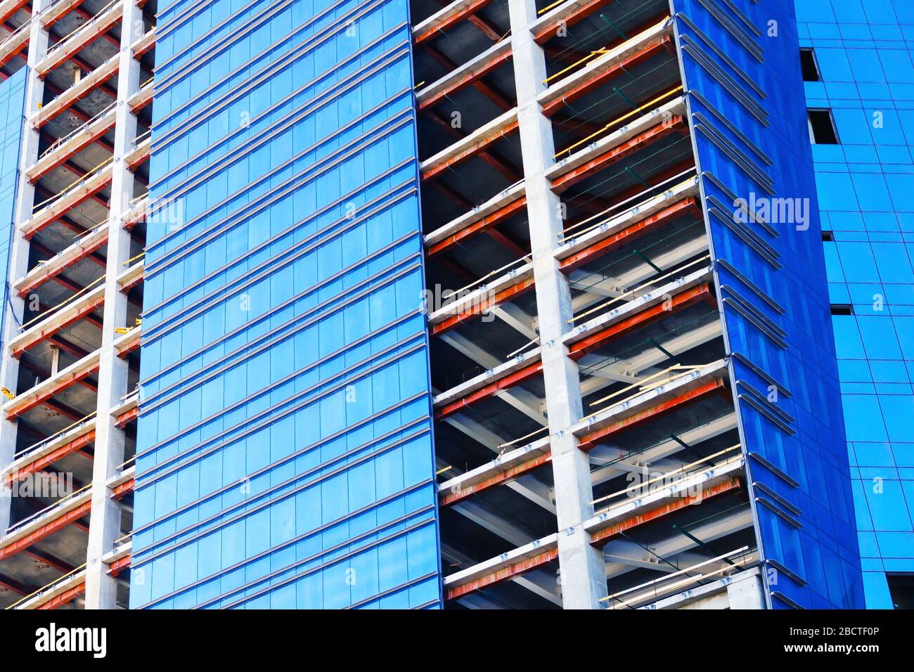 Il concetto di costruzione di più unità, edifici di uffici. Città ​​skyscrapers. Luogo di costruzione. Finestre blu, facciata a specchio Foto Stock