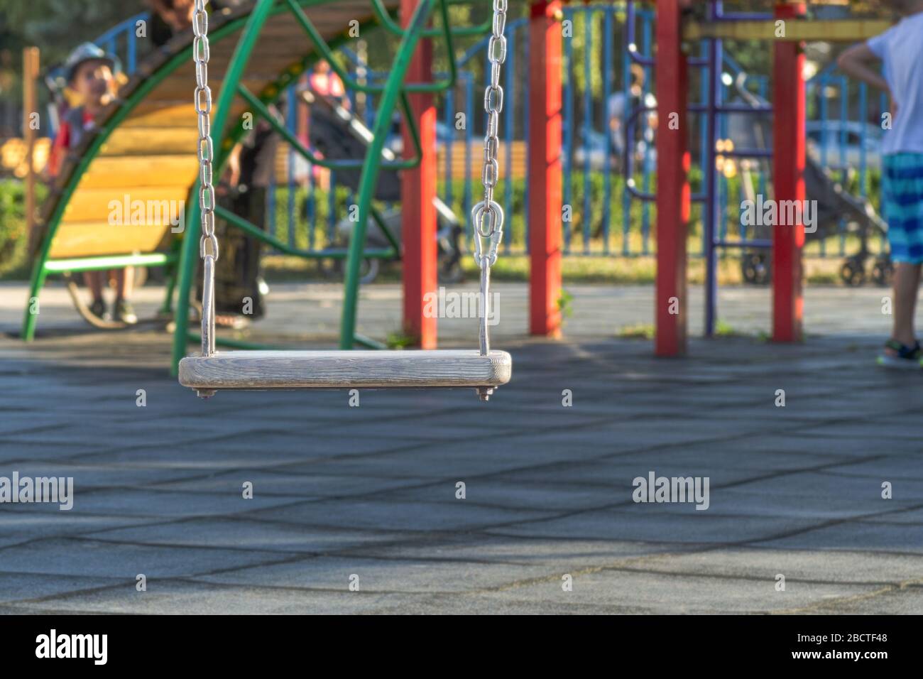 swing vuoto al parco giochi. Il concetto di infanzia e divertimento. Placca di legno su una catena metallica Foto Stock