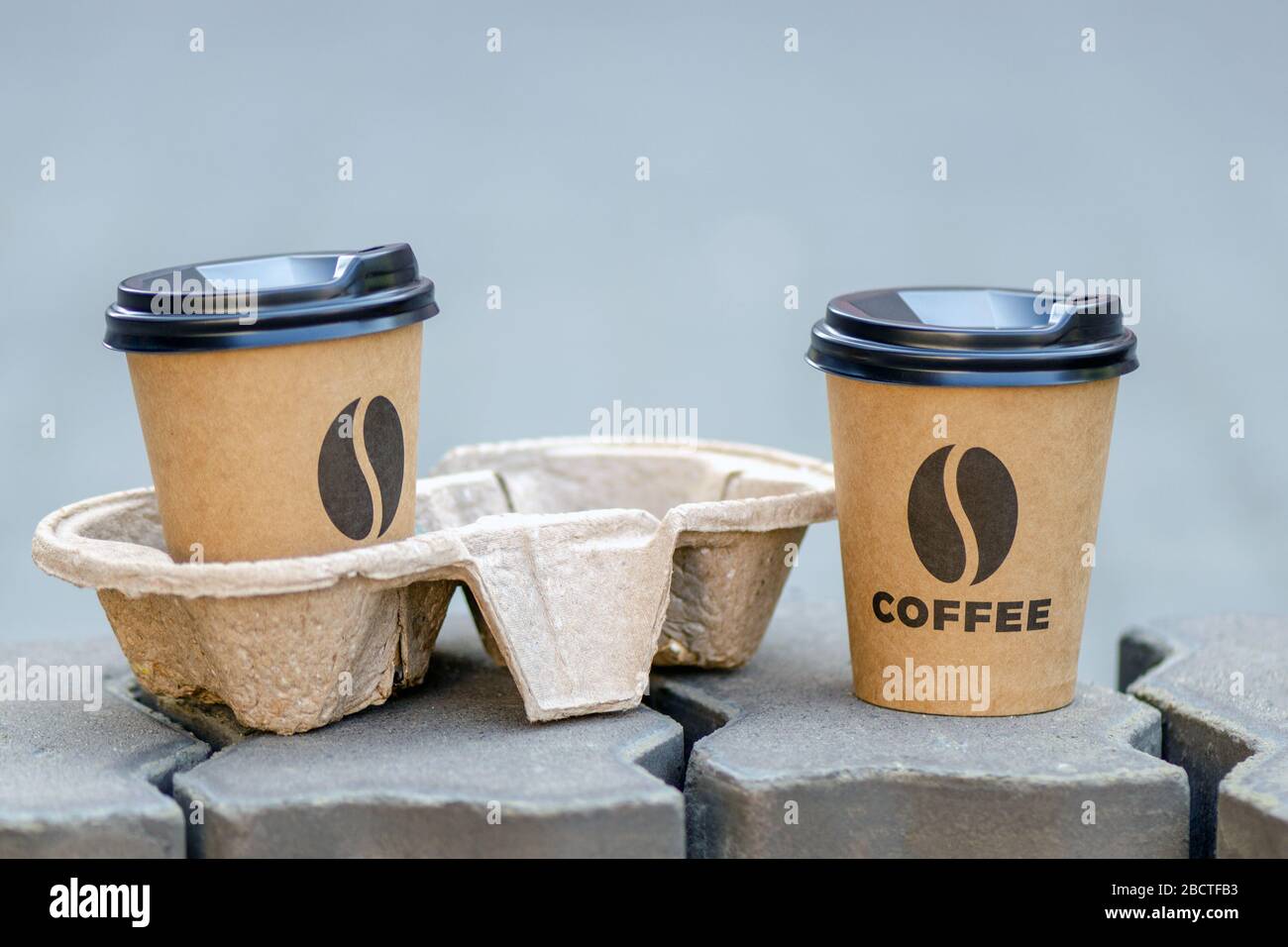 due tazze da asporto di caffè. una tazza nel supporto. concetto di caffè da asporto Foto Stock