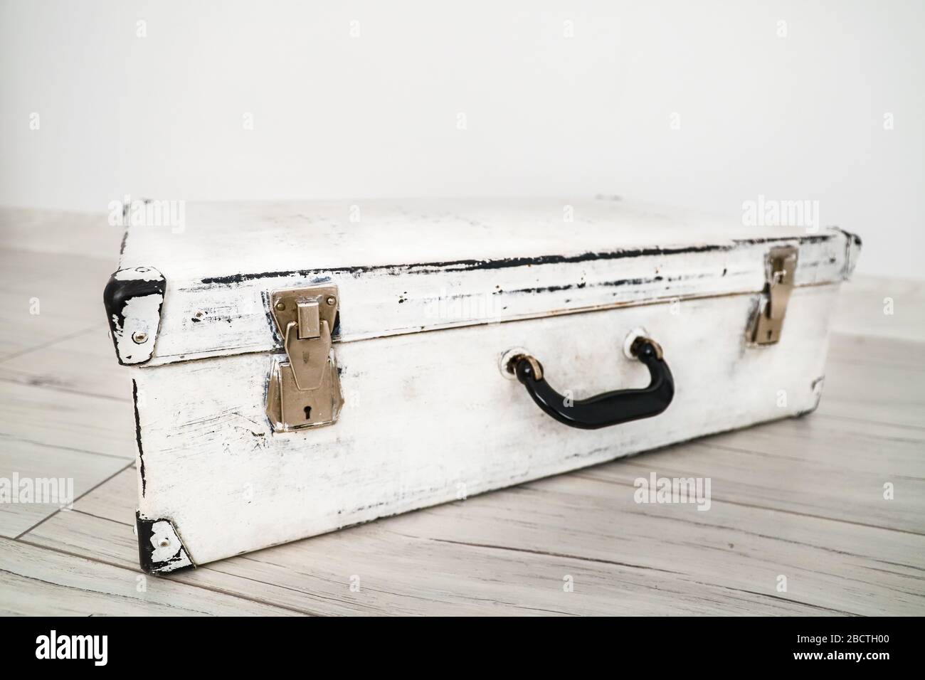 Usato vecchia valigia bianca vintage sul pavimento Foto stock - Alamy