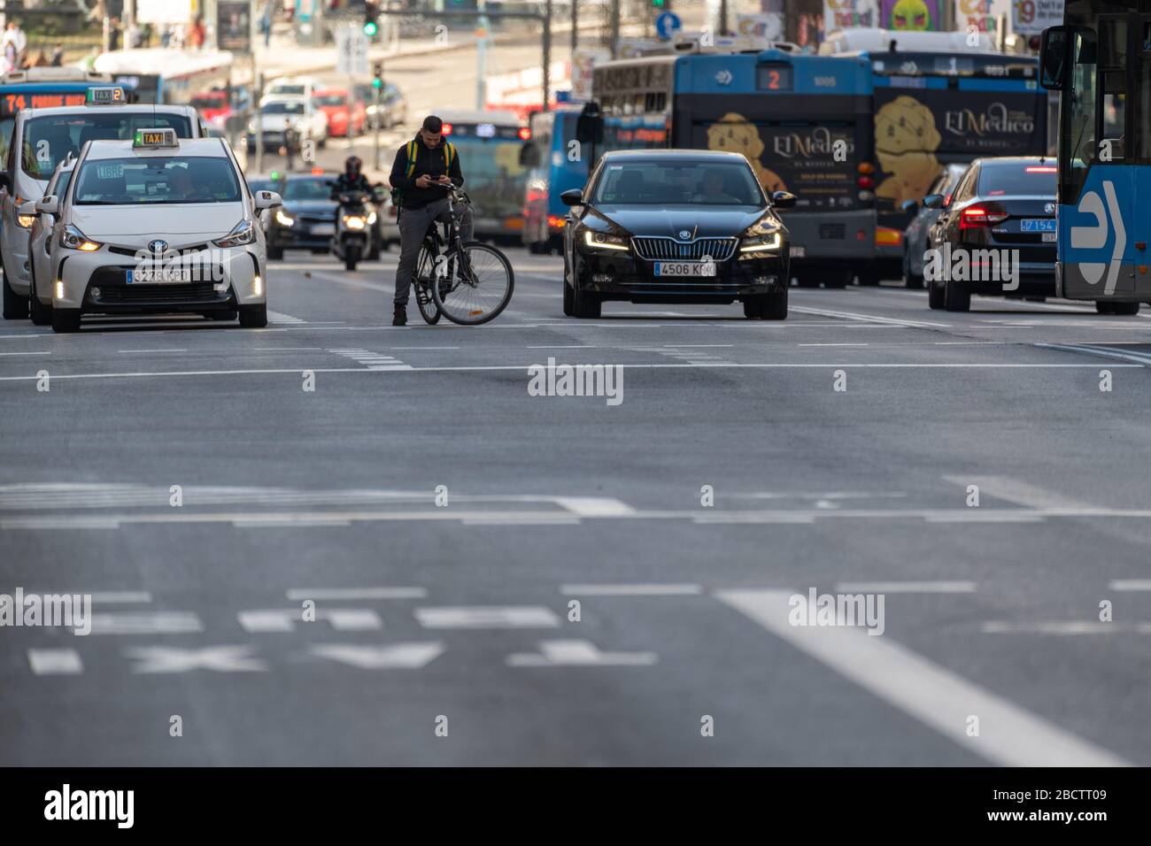 MADRID, SPAGNA - 24 FEBBRAIO 2019: Autobus urbani, auto, biciclette e motociclette sono in attesa al semaforo nella trafficata Gran Via di Madrid, una delle strade principali Foto Stock