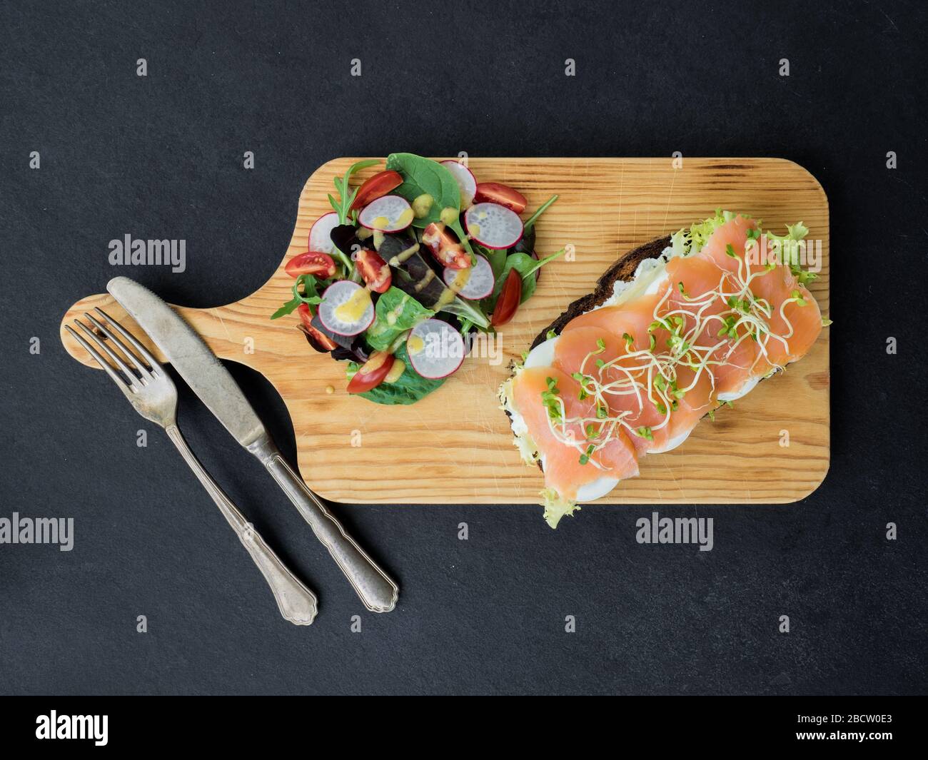Bruschetta di salmone affumicato e insalata su una tavola meravigliosa. Vista dall'alto Foto Stock